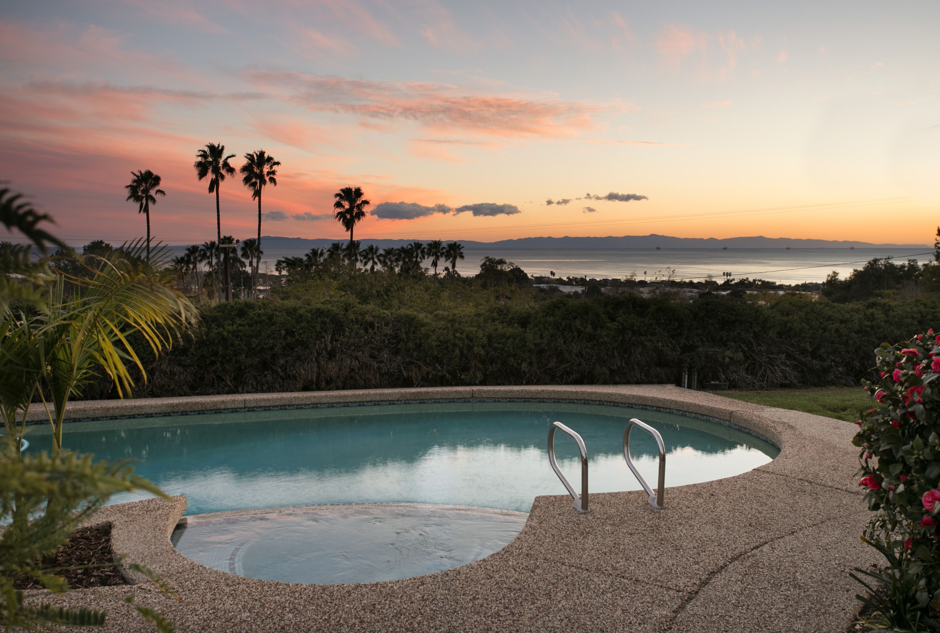 backyard pool with view of ocean